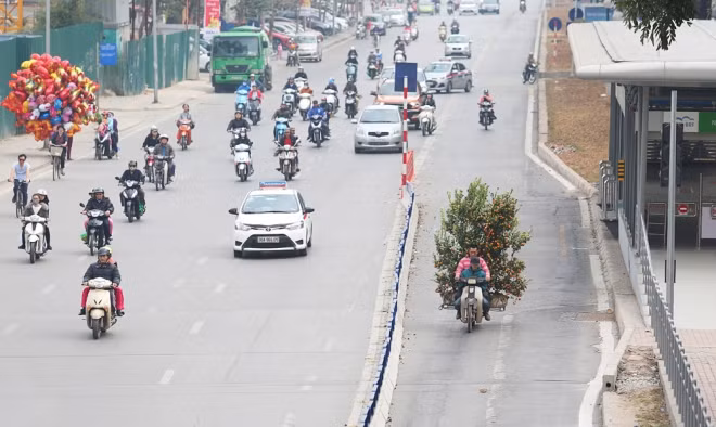 Đường Giảng Võ lúc 12h trưa. Một người dân chở cây cảnh đi vào phần đường dành riêng cho xe buýt nhanh.