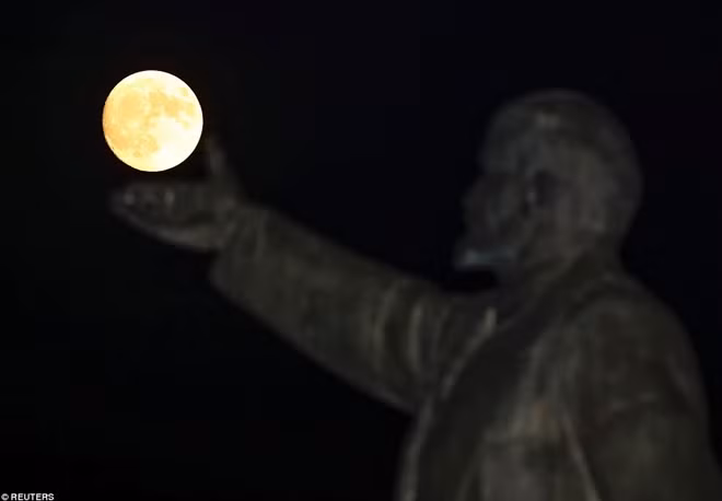 Bức ảnh ghi lại khoảnh khắc đặc biệt khi siêu trăng xuất hiện bên trên tượng lãnh tụ Lenin, Nga. Ảnh: Reuters