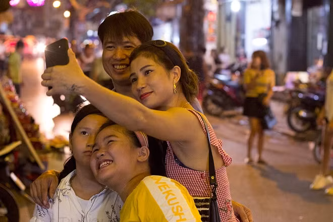 Trong khi cả gia đình này cũng chọn khu phố Hàng Mã làm nơi đi chơi buổi tối.