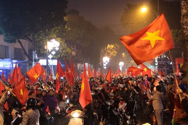 Trời Hà Nội đổ mưa nhưng không thể cản được người dân đổ xuống đường ăn mừng chiến tích lịch sử của bóng đá nước nhà.