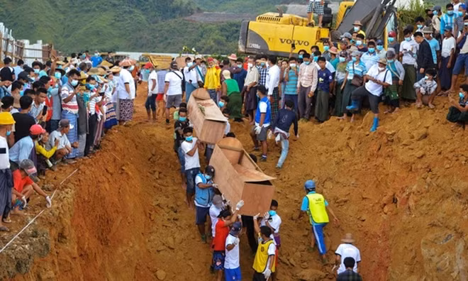 Tình nguyện viên đưa quan tài thợ mỏ thiệt mạng trong vụ lở mỏ ngọc ở bang Kachin, Myanmar xuống hố chôn tập thể hôm 3-7.