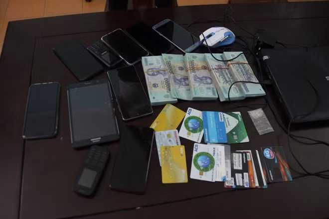 Số tiền, điện thoại, thẻ ATM thu giữ của các đối tượng.