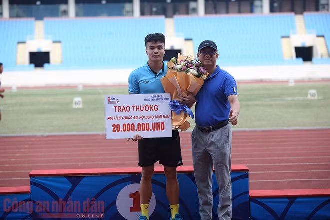 VĐV Ngần Ngọc Nghĩa nhận phần thưởng từ ban tổ chức nhờ phá kỷ lục của chính mình.