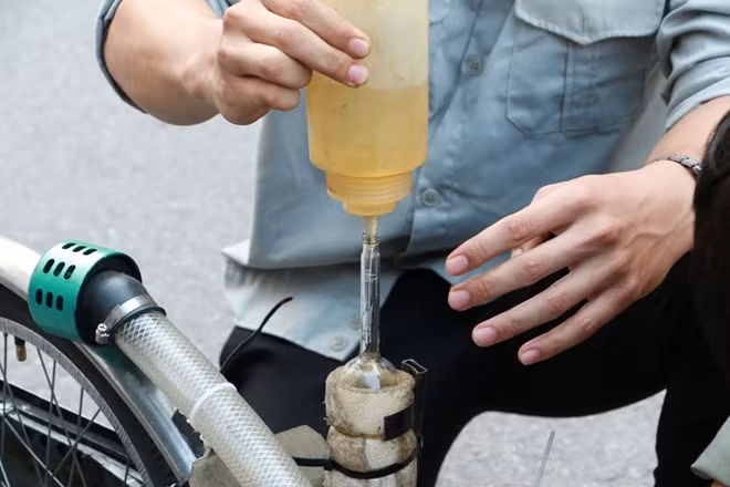 Nhiên liệu được bơm tay vào một bình nhỏ trong xe.