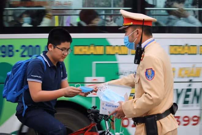 Đội CSGT số 6 Công an Hà Nội phân luồng giao thông, kịp thời phát khẩu trang cho người dân đảm bảo an toàn trước diễn biến mới của dịch COVID-19.