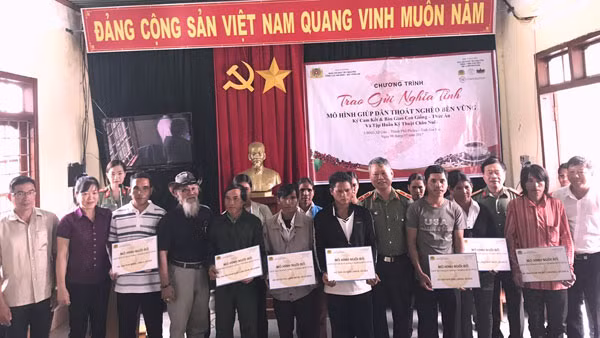 Lãnh đạo Cục An ninh Tây Nguyên cùng nhà tài trợ trao bảng tượng trưng nhận bò cho các hộ dân.