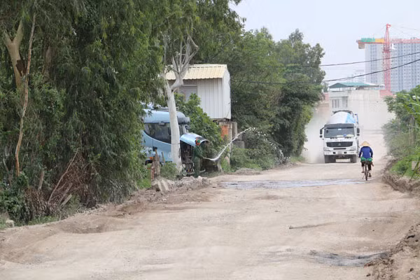 Cách người dân gần đường làm giảm bụi bay mỗi khi trời nắng.