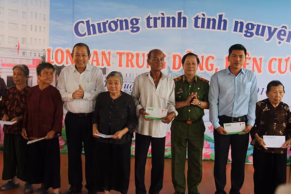 Phó Thủ tướng thường trực Trương Hòa Bình và Trung tướng Nguyễn Xuân Yêm tặng quà cho các đại diện gia đình chính sách.