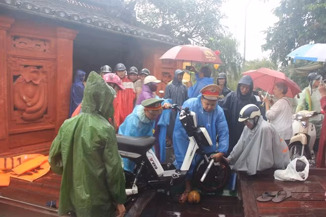 Công an TP Hội An túc trực, giúp người dân đi tránh lũ tại điểm chùa Cầu, phố cổ Hội An.