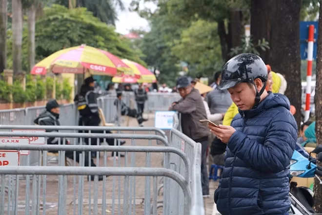 Nhiều người dân hiếu kỳ tập trung bên ngoài hàng rào này.