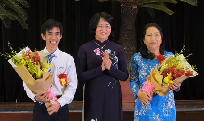Phó Chủ tịch Nước Đặng Thị Ngọc Thịnh (giữa) chúc mừng luật sư Trần Thị Ngọc Nữ (bên phải) tại lễ tuyên dương gương tập thể, cá nhân Thầm lặng mà cao cả.