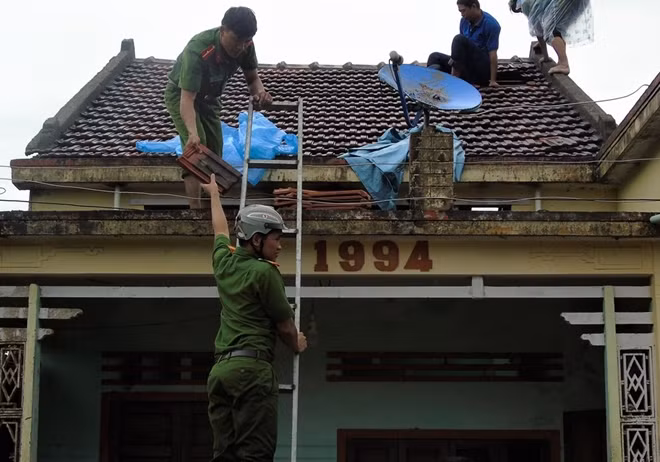 Công an huyện Mộ Đức giúp dân lợp nhà.