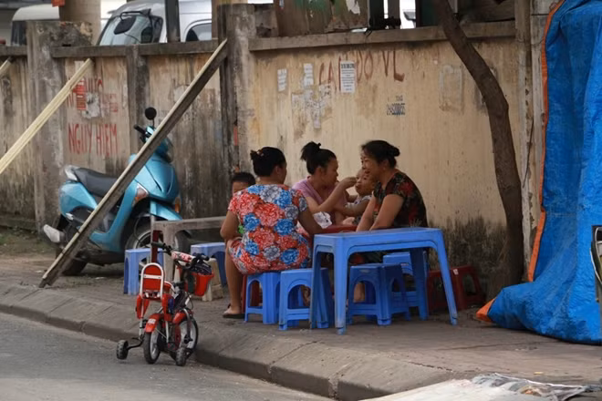 Nhiều người thản nhiên ngồi uống trà đá, thậm chí cho cả trẻ con ra chơi bên cạnh bức tường có thể đổ sập bất cứ lúc nào.