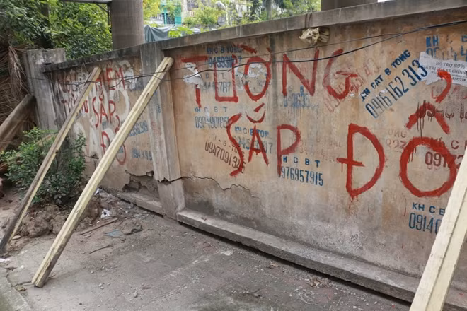 Trên mặt tường có những dòng chữ cảnh báo nguy hiểm.