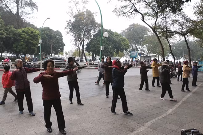 Bất chấp trời mưa lạnh, từ sáng sớm đã có rất nhiều người cao tuổi tập trung trước cửa đền Quán Thánh để tập thể dục.