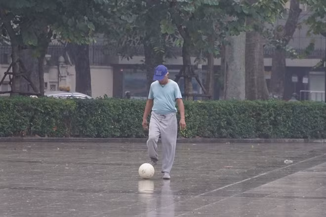 Một cụ ông có bài tập thể dục khá lạ là đá bóng.