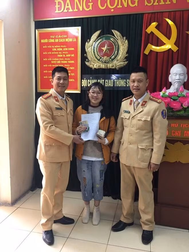 Chị Vũ Hoàng Anh nhận lại tài sản từ cán bộ CSGT Hà Nội.