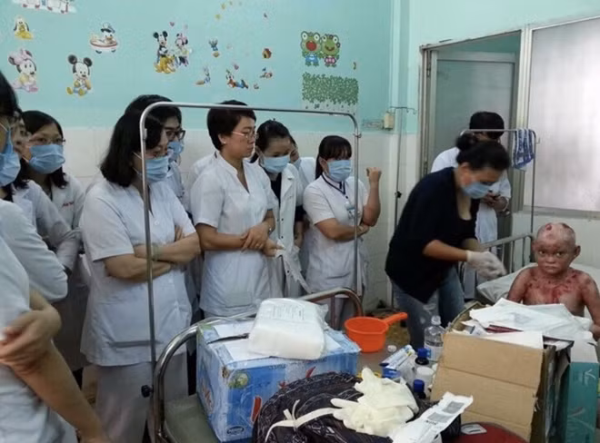 Chị Lan (áo đen) đang chăm sóc một bệnh nhị bị EB tại bệnh viện.