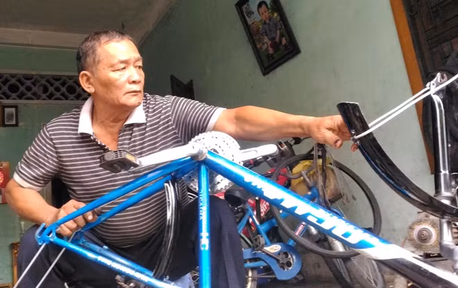 Ông Hoàng Tiến Mai sửa chữa xe đạp cho khách hàng.