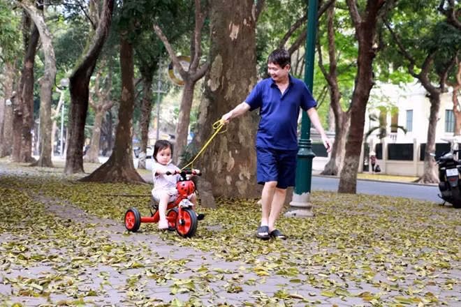 Hai cha con trên đoạn vỉa hè ngập lá rụng tại đường Phan Đình Phùng.