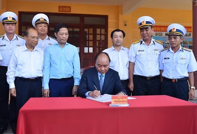 Thủ tướng ghi sổ vàng truyền thống của Lữ đoàn. Ảnh: VGP/Quang Hiếu