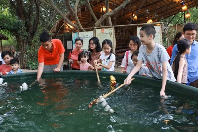 Một số bé khác thử cảm giác làm nghệ sĩ múa rối nước.