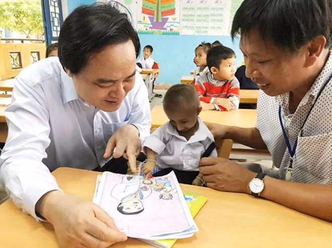 Bộ trưởng Bộ Giáo dục và Đào tạo Phùng Xuân Nhạ với cậu học trò tý hon Đinh Văn KRể và thầy chủ nhiệm.