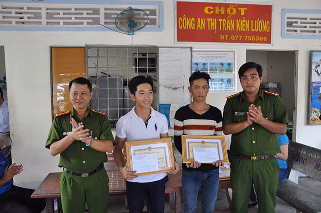Đại diện Công an huyện Kiên Lương trao Giấy khen của Chủ tịch UBND huyện tặng 2 anh Phan Quốc Đạt và Võ Thành Đức.