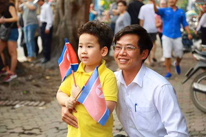 Những người dân hào hức chờ đón đoàn xe của Chủ tịch Triều Tiên Kim Jong-un trên phố Lý Thường Kiệt.