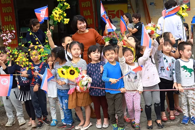 Cô và trò trường Mầm non A (phố Thợ Nhuộm, Hà Nội) vẫy hoa và cờ chào mừng Chủ tịch Triều Tiên.