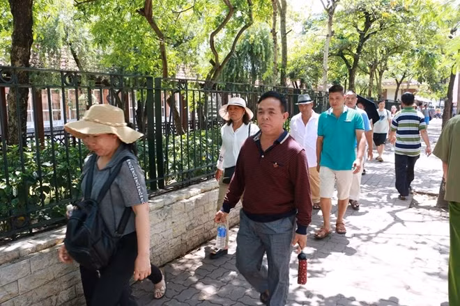 Khoảng 11h, Ban quản lý tạm ngưng đón khách vào viếng lăng. Trong ảnh là một đoàn khách di chuyển ra khỏi khu vực Lăng sau khi vào viếng Bác.
