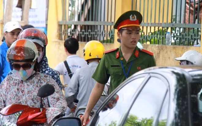 Không chỉ cõng thí sinh, Phan Tuấn Hùng còn tham gia công tác điều tiết giao thông tại khu vực cổng trường trước và sau giờ thi. (Ảnh: Lê Văn)