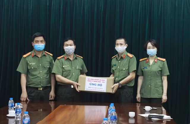 Đại tá Nguyễn Văn Thống tiếp nhận các sản phẩm hỗ trợ phòng chống dịch COVID-19 do Phó Tổng Giám đốc Công ty Thanh Bình trao tặng.