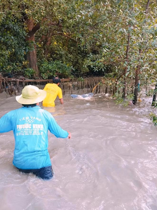 Ông Nguyễn Văn Bờ và người dân cùng cứu cá heo mắc cạn đưa ra biển.