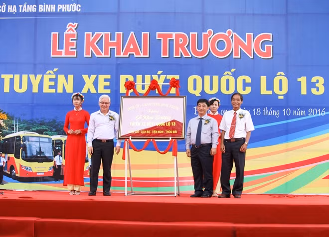 Ông Nguyễn Văn Lợi (bên trái) – Bí thư Tỉnh ủy Bình Phước tặng bức tranh cho lãnh đạo Công ty cổ phần đầu tư xây dựng cơ sở hạ tầng Bình Phước nhân dịp lễ khai trương tuyến xe buýt quốc lộ 13 - ảnh: ĐỨC TRÍ