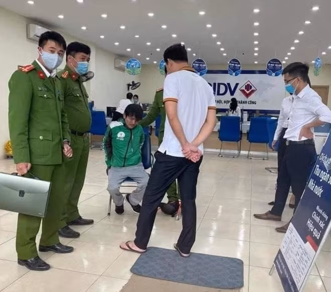 Đối tượng cướp Hào (mặc đồng phục Grab) sau khi bị bắt giữ.
