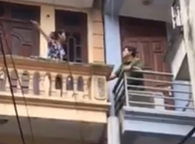 Tại ban công tầng 3, Đại tá Lê Đức Hùng khống chế thành công người phụ nữ dọa tự thiêu. (Ảnh cắt từ clip quay tại hiện trường)