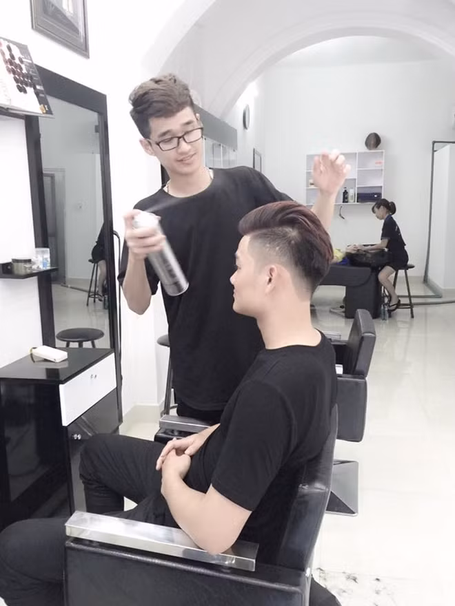 Văn Khắc Huấn đang tạo mẫu tóc cho khách.