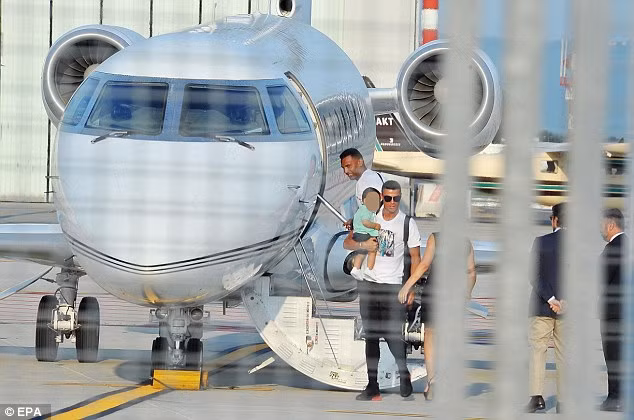 Ronaldo bế cậu con trai nhỏ rời máy bay riêng tại sân bay Turin.