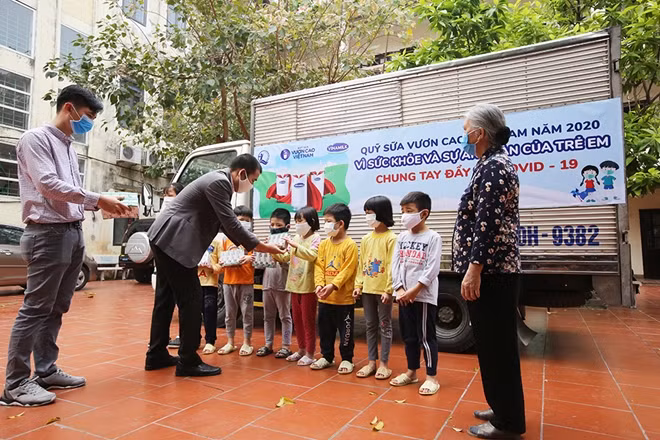 Đại diện công ty Vinamilk tặng sữa cho trẻ em tại Trung tâm nuôi dưỡng trẻ mồ côi Hà Cầu, Hà Nội.