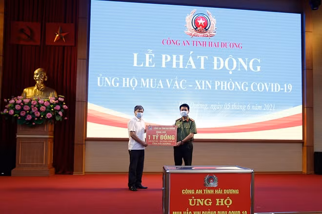 Đại tá Lê Ngọc Châu, Giám đốc Công an tỉnh Hải Dương trao số tiền ủng hộ 1 tỷ đồng cho Quỹ vắc xin phòng COVID-19.