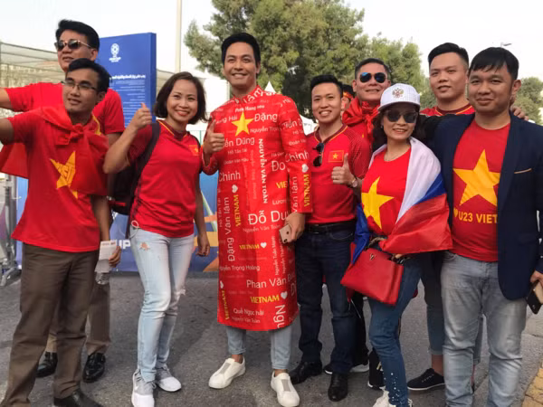 MC Phan Anh (giữa) chụp ảnh cùng các CĐV khác, trước khi vào sân. Ảnh: AFC.