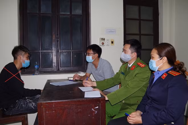 Trần Mạnh Hùng (bìa trái) tại cơ quan Công an.