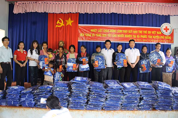 Các thành viên Qũy Bảo trợ trẻ em Việt Nam tặng quà cho các hộ gia đình.