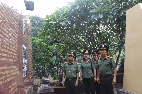 Thiếu tướng Mai Văn Hà và các đại biểu tìm hiểu lịch sử tại mộ Nhà yêu nước Nguyễn An Ninh