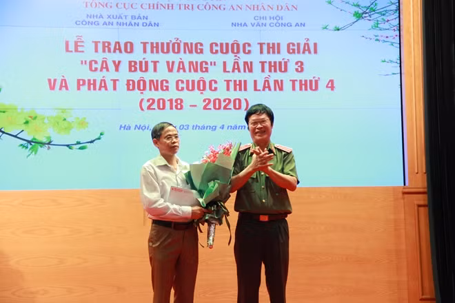 Trung tướng, nhà văn Hữu Ước tặng hoa tác giả Nguyễn Đức Nguyên trong buổi lễ trao giải Cây bút vàng lần thứ 3.