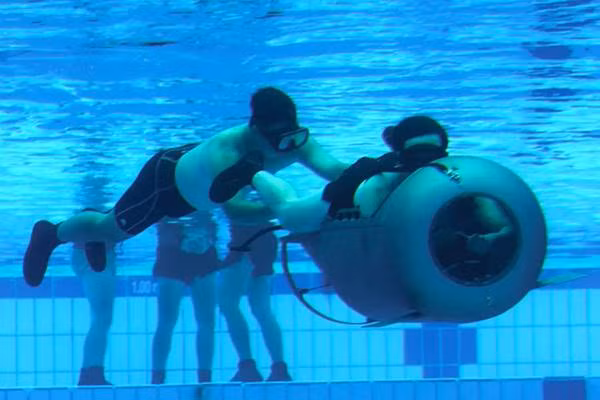 Thành viên NDU huấn luyện với thiết bị đẩy của thợ lặn trong một bể bơi.