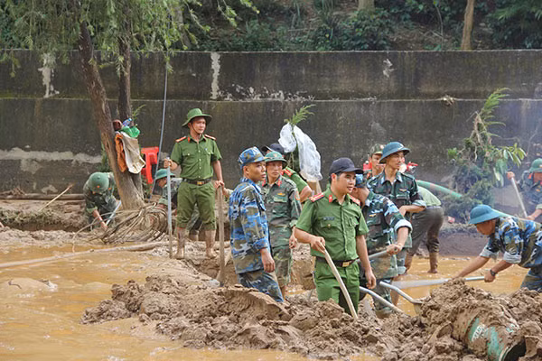 Công an huyện Mai Sơn “lội bùn” giúp thầy cô giáo khắc phục hậu quả sau mưa lũ.