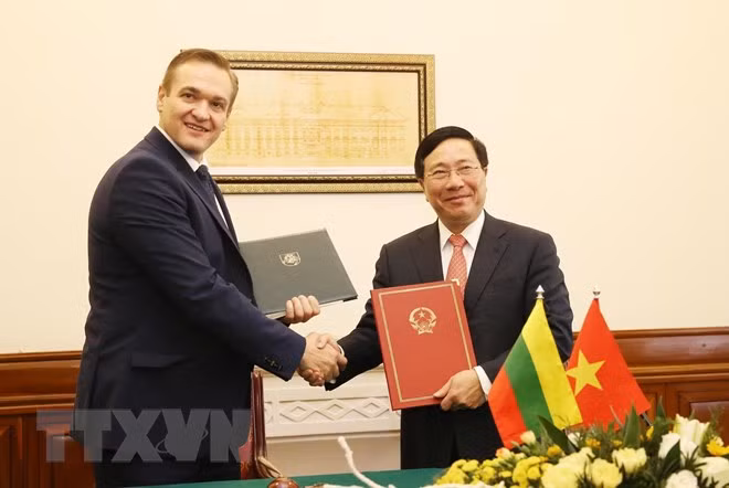 Phó Thủ tướng, Bộ trưởng Bộ Ngoại giao Phạm Bình Minh và Bộ trưởng Bộ Nội vụ Cộng hòa Lithuania Eimutis Misiunas ký Hiệp định miễn thị thực cho người mang hộ chiếu ngoại giao giữa hai nước. (Ảnh: Lâm Khánh/TTXVN)
