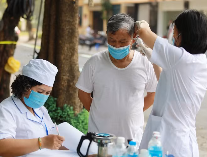 Cán bộ y tế kiểm tra thân nhiệt của người dân trong khu vực cách ly. Cán bộ y tế kiểm tra thân nhiệt của người dân trong khu vực cách ly.